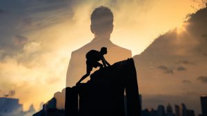Silhouette of a climber scaling a rock overlaid with a suited figure against a sunrise symbolizing resilience and ambition