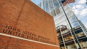 Exterior of John Joseph Moakley United States Courthouse with a brick facade modern glass building and an American flag flying