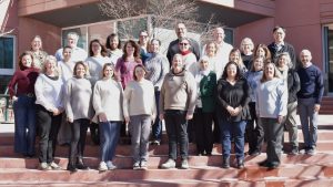 Group photo of APHLI Scholars standing on outdoor steps in front of a modern building during APHLI retreat